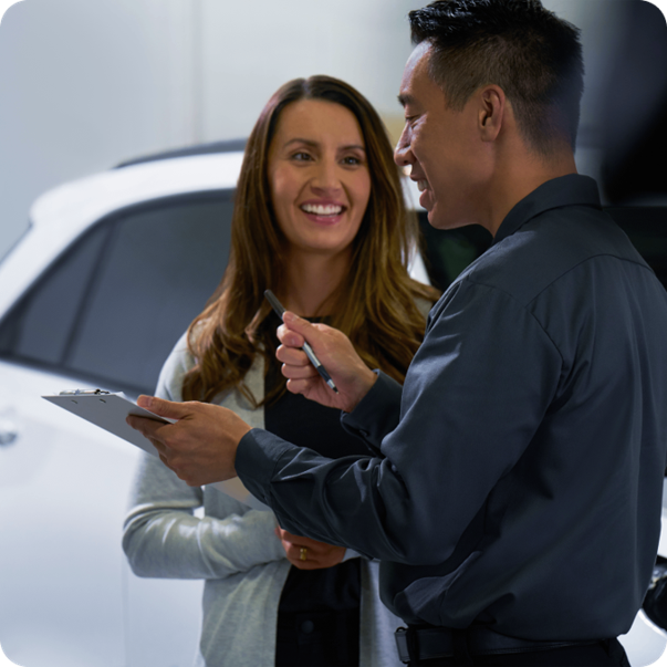 Asesor de Chevrolet conversando con una clienta en un concesionario.
