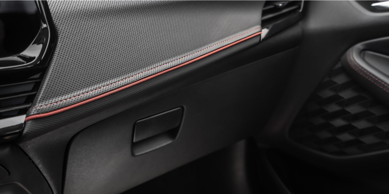 Vista en detalle de la guantera en color Jet Black con detalles en rojo y negro High Gloss.