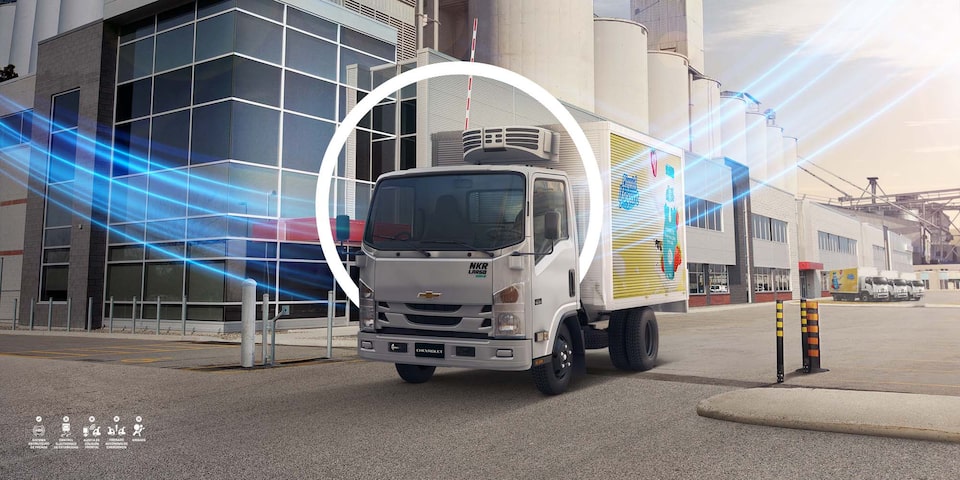 Camión Chevrolet de carga refrigerada estacionado en un complejo industrial, resaltando soluciones de transporte inteligente.